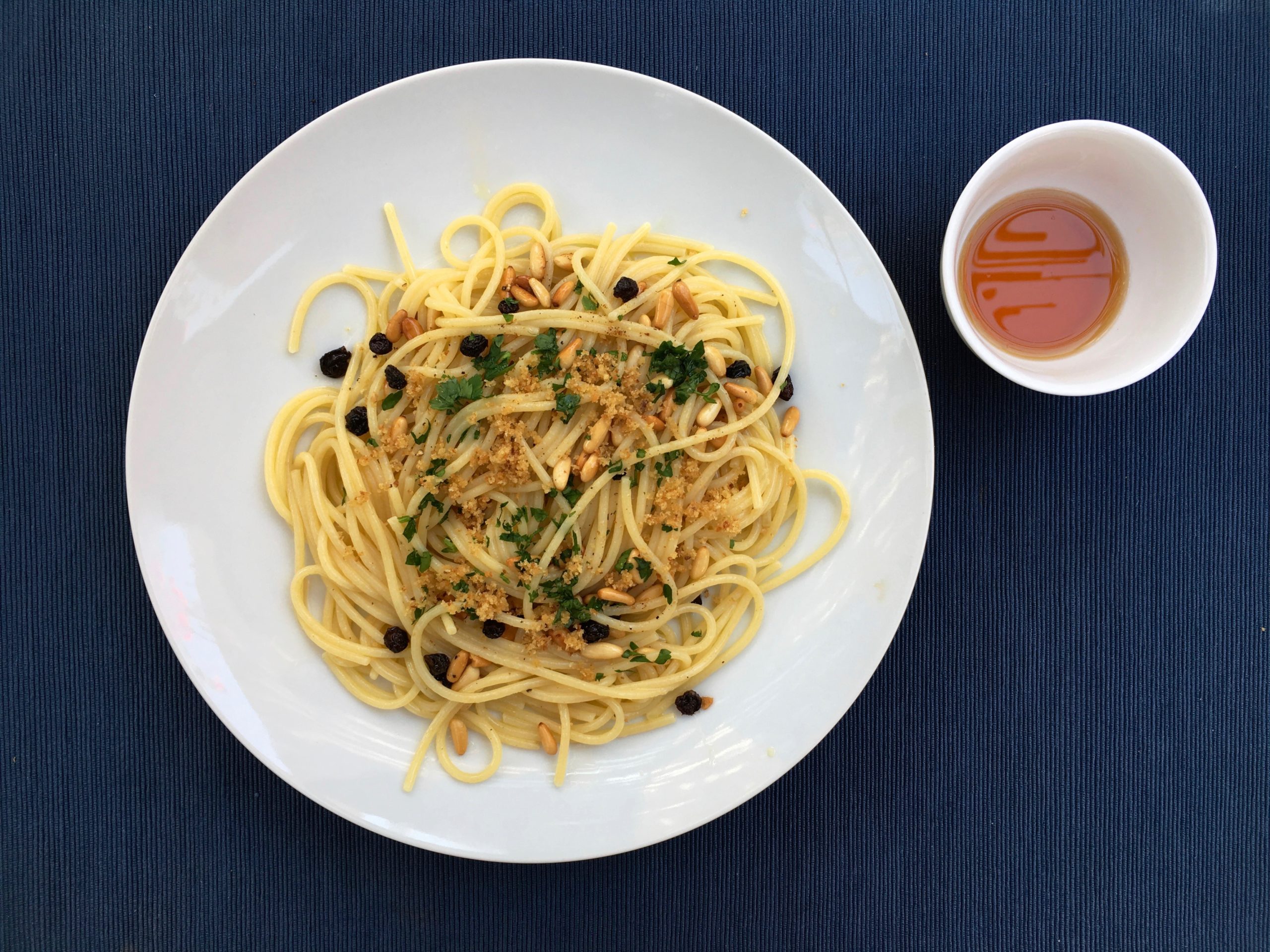 Pasta con la colatura di alici, uva passa, pinoli e ...